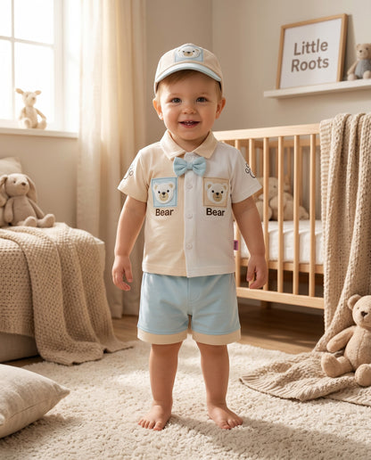 Little Roots baby boy 3-piece outfit set with cream shirt, blue shorts, and cap. Features bear embroidery and a bow tie.