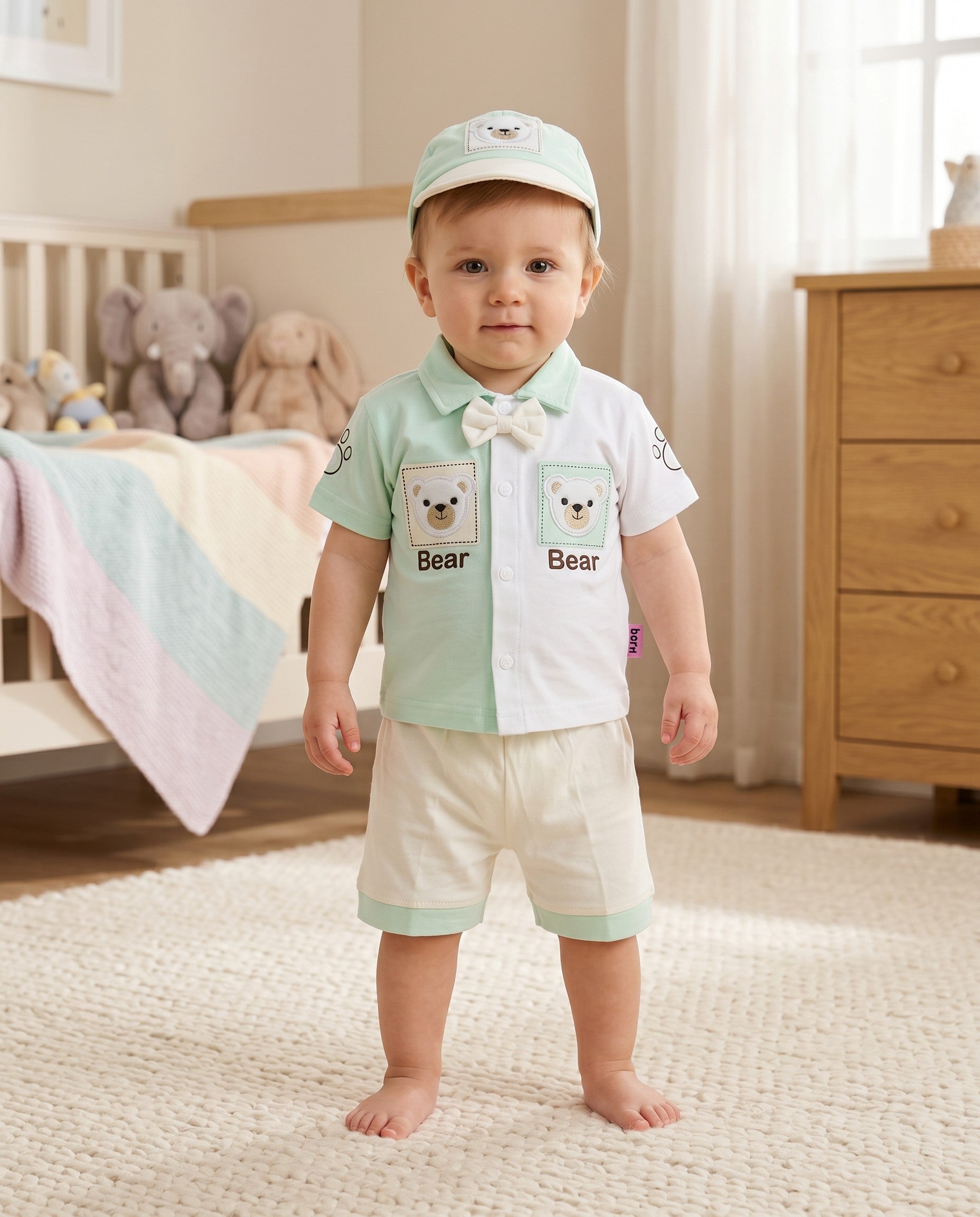 Little Roots baby boy 3-piece outfit set: mint green & white shirt with bear design, bow tie, matching shorts, and cap. Soft cotton.