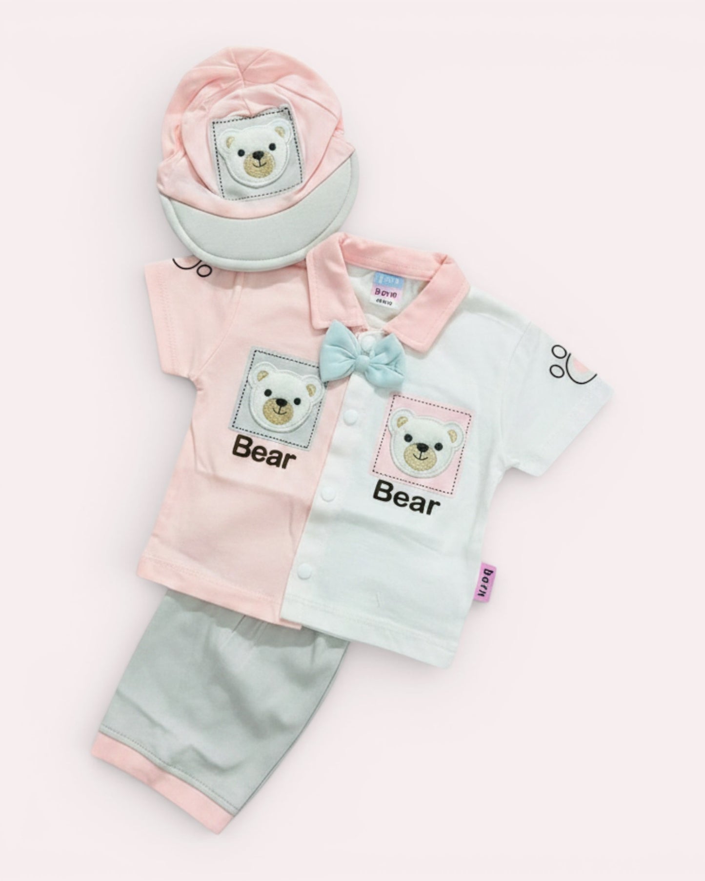 Little Roots baby boy 3-piece outfit set with pink & white bear print shirt, blue bow tie, grey shorts, and cap. Soft cotton blend.