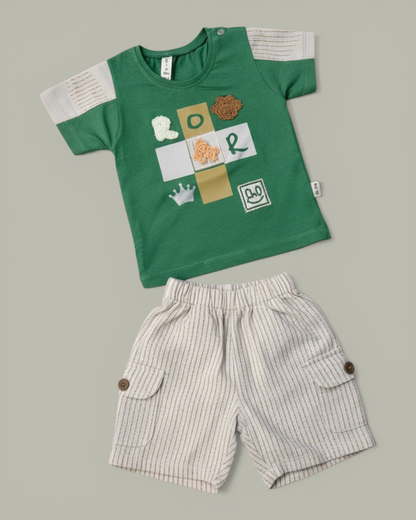 Little Roots baby boy green cotton t-shirt with "ROAR" graphic and beige cargo shorts. Summer outfit.