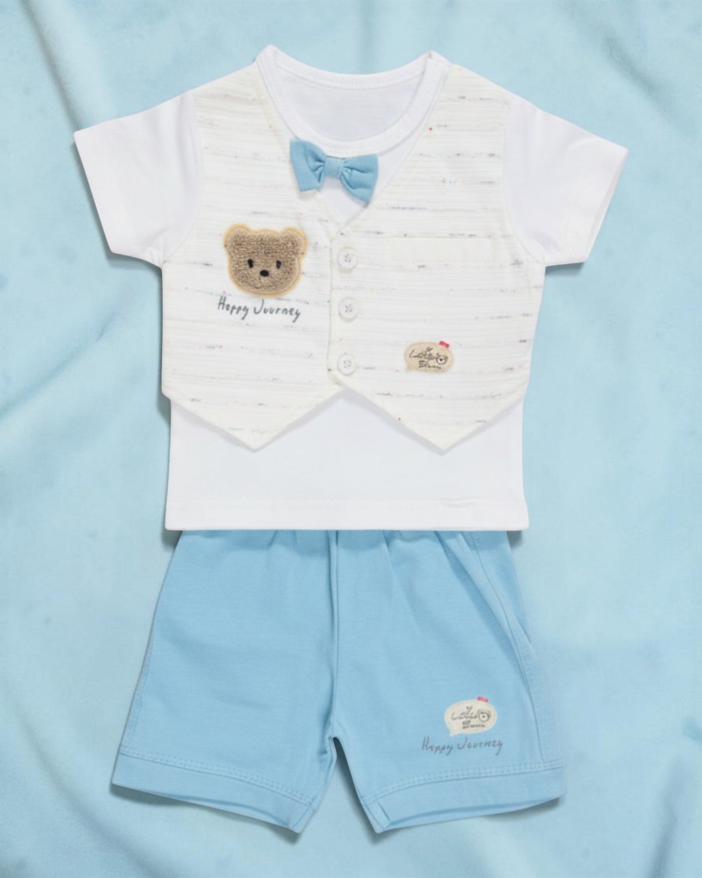 Little Roots baby boy white t-shirt with blue bow and teddy patch, paired with light blue shorts. Cotton summer outfit.