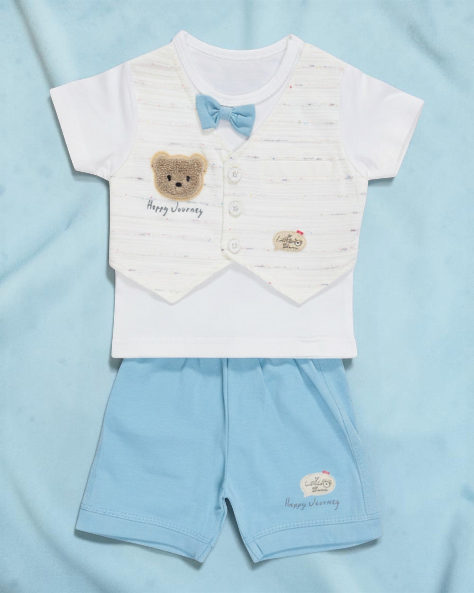 Little Roots baby boy white t-shirt with blue bow and teddy patch, paired with light blue shorts. Cotton summer outfit.
