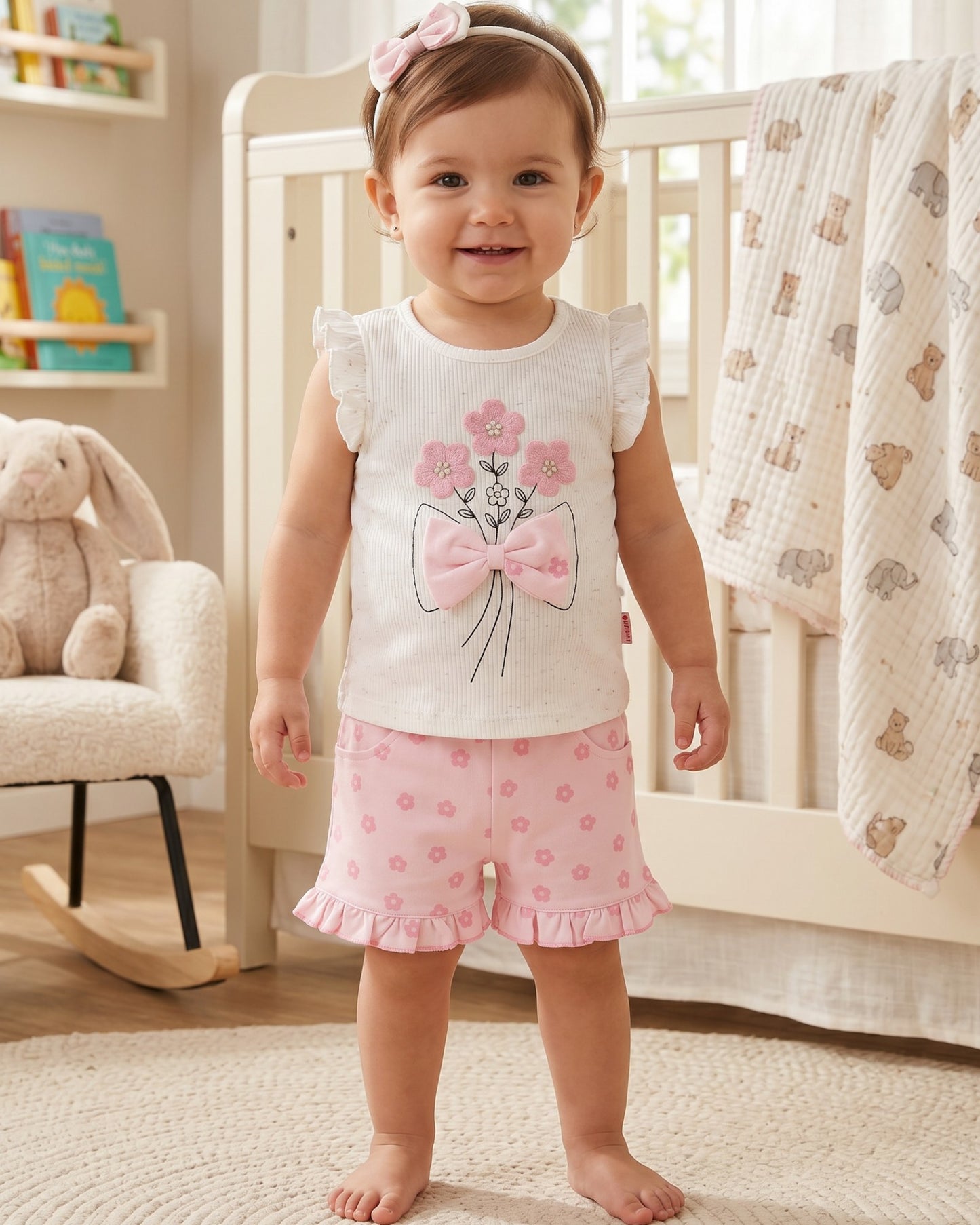 Little Roots baby girls' white floral embroidered top with pink bow and matching pink floral shorts and headband. Ruffled sleeves and hem.