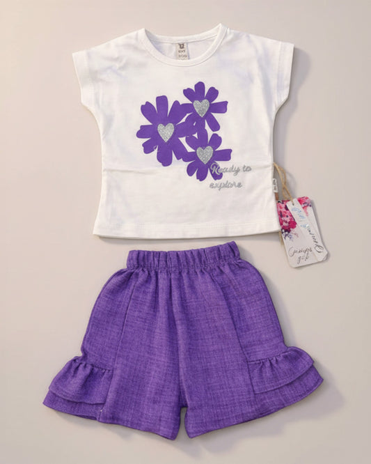 Little Roots Pakistan white t-shirt with purple floral print and glitter hearts, paired with purple ruffle shorts. "Ready to explore" text.