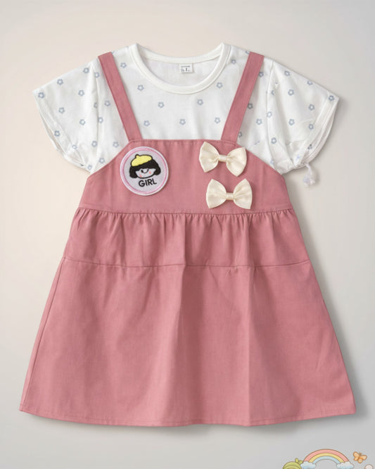 Little Roots baby girl pink pinafore dress with white floral print top, "Girl" patch, and double bow accents.