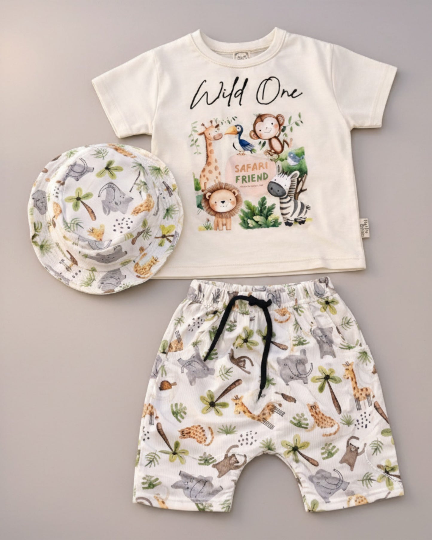 Little Roots Pakistan baby boy 3-piece safari jungle outfit: cream t-shirt with animal print, matching shorts, and bucket hat.